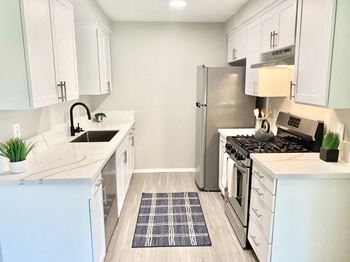 a kitchen with white cabinets and a stainless steel refrigerator at BLVD Apartments LLC, Tarzana California